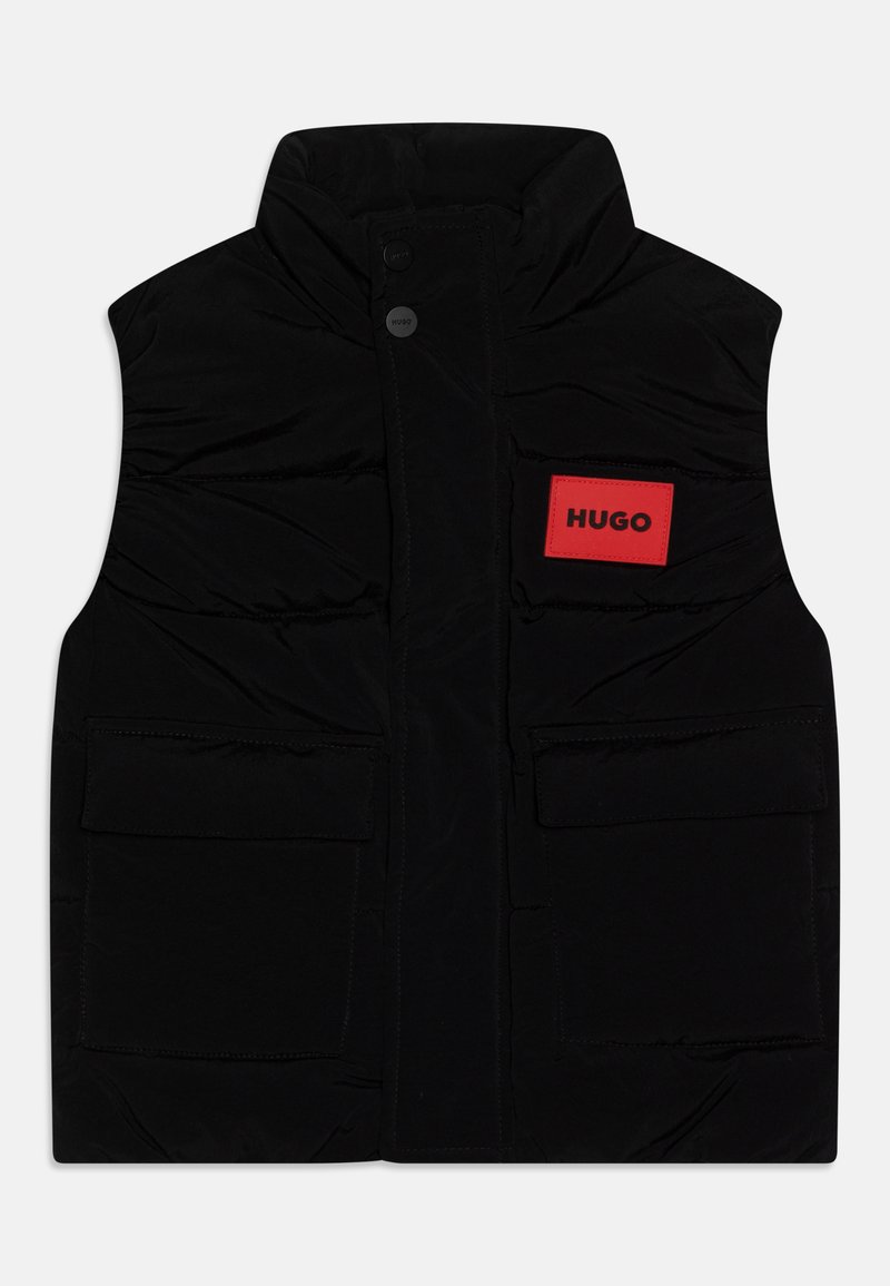 Svart polstret vest med høy krage, frontknapplukking og to store frontlommer. Har et rødt rektangulært merke med "HUGO"-etikett.