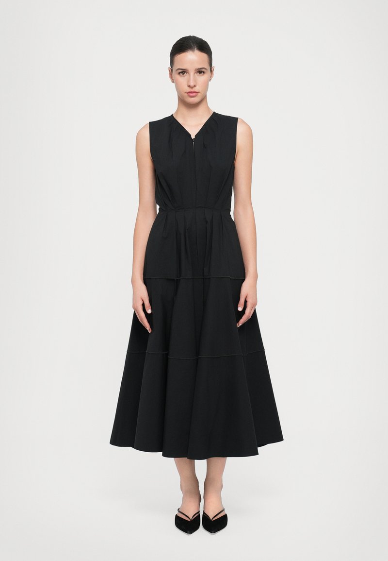 Vestido midi negro sin mangas con un corsé ajustado, diseño en capas y costuras visibles. Tela suave con una silueta fluida.