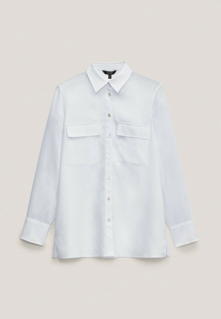 Chemise blanche à manches longues boutonnée avec deux poches avant à rabat et un col pointu, posée à plat sur un fond clair.