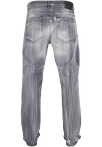 Jeans in denim grigio con una texture sbiadita e effetto vissuto. Presentano cinque tasche e un design a gamba dritta. La vista posteriore mostra i dettagli delle cuciture.
