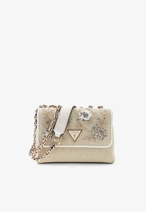 Sac à main beige Guess avec broderie florale en sequins, bandoulière chaîne dorée tissée de cuir blanc, et logo triangulaire en métal de la marque sur le rabat avant.