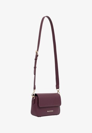 Bolso de hombro de cuero burdeos con cierre de solapa, herrajes dorados, correa ajustable y logo grabado en el frente. Diseño compacto y estructurado.