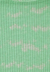 Tessuto verde chiaro con texture a righe verticali, caratterizzato da sottili motivi bianchi. Il materiale sembra morbido e leggermente peloso.