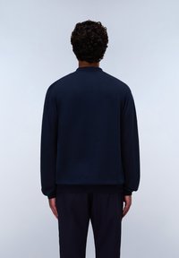 Maglione a girocollo di colore blu navy, con polsini a costine e vestibilità ampia. Realizzato in un tessuto morbido, con una texture liscia e dettagli minimi.