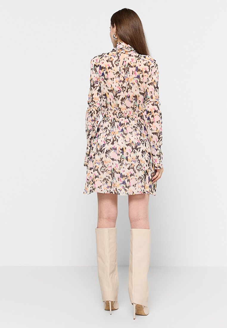 Sukienka w kwiatowy wzór w jasnych odcieniach, z długimi rękawami, zebranym w talii oraz lekko rozkloszowanym dołem. Połączona z beżowymi botkami do kolan.