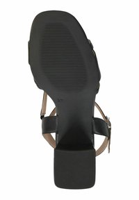 Mustat korkokengät, joissa on tasainen kumipohja, vaaleanruskeat hihnat ja neliönmuotoinen korko. Varustettu soljella ja uritetulla pinnalla pohjassa.