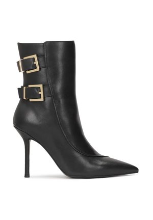 Black leather ankle boot with a pointed toe and stiletto heel. Features two gold-tone buckles on the side, with a smooth texture.