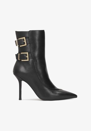 Juodai odiniai kulkšnies botai su smailiu kojų pirštu ir stileto aukštu kulnu. Šone yra du auksiniai užsegimai ir lygus paviršius.