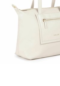 Beige tote taske lavet af glat syntetisk læder, med en frontlomme med lynlås og guldfarvet hardware. Stærke håndtag til at bære.