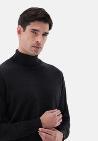 Dunkelgrauer Rollkragenpullover aus weichem Strickmaterial, mit einer figurbetonten Passform, gerippten Bündchen und glatter Textur. Minimalistischer Stil.