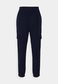 Calças cargo azul-marinho com cintura elástica, punhos ajustados e bolsos laterais. Feitas de um tecido macio com uma textura suave.