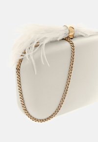 Balta dirbtinė odos rankinė su auksine grandine, su tekstūriniu plunksnų akcentu ir lygia paviršiumi. Elegantiškas ir minimalistinis dizainas.