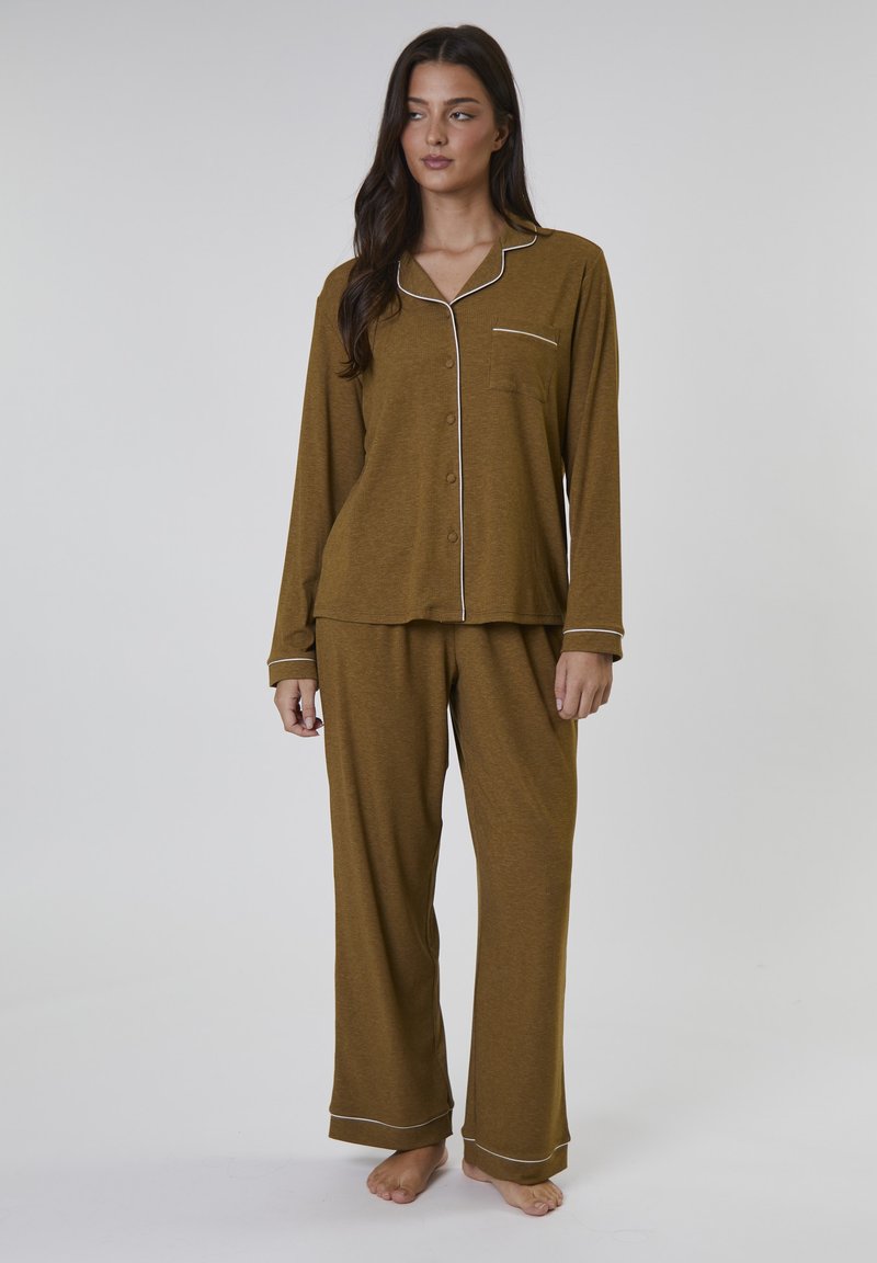 Brun tvådelad pyjamas i mjukt tyg. Långärmad topp med vit kantning och bröstficka; matchande långa byxor med liknande detaljer.
