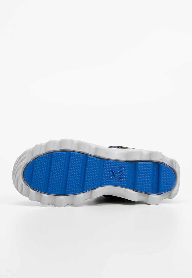 Niebieska gumowa podeszwa buta z teksturowanym wzorem gripu i wypukłymi rowkami. Charakterystyczny falisty kształt i kontrastująca biała krawędź.