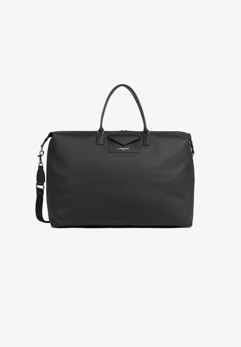 Sac de voyage en nylon noir avec deux poignées supérieures, une bandoulière réglable et une poche avant avec rabat. Présente une texture subtile et un logo.