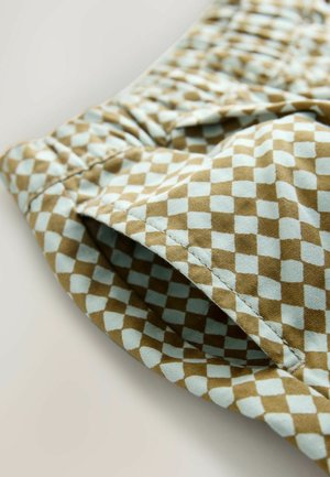 Braun und hellblau kariertes Stoffmaterial mit strukturierter Oberfläche, ausgestattet mit einem elastischen Öffnungsbereich und sichtbaren Nahtdetails.