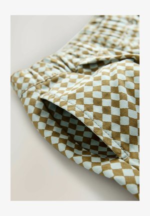 Brūns un gaiši zils rūtainas auduma ar teksturētu virsmu, ar elastīgu atvērumu un redzamu šuvju detaļu.