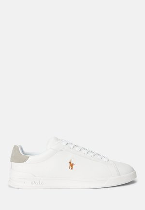Zapatilla blanca con material sintético suave, puntera redonda y diseño con cordones. Presenta un acento en ante gris claro en el talón y un logo bordado.