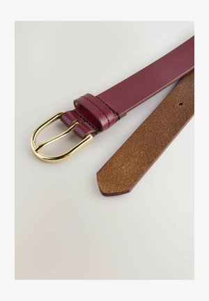 Burgundy leather belt with a gold metal buckle, featuring a smooth finish and a pointed end. The reverse side has a brown suede-like texture.