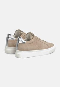 Sneaker beige in suede con suola in gomma bianca, dettagli argentati e un collare decorativo con perline sul retro vicino al tallone.