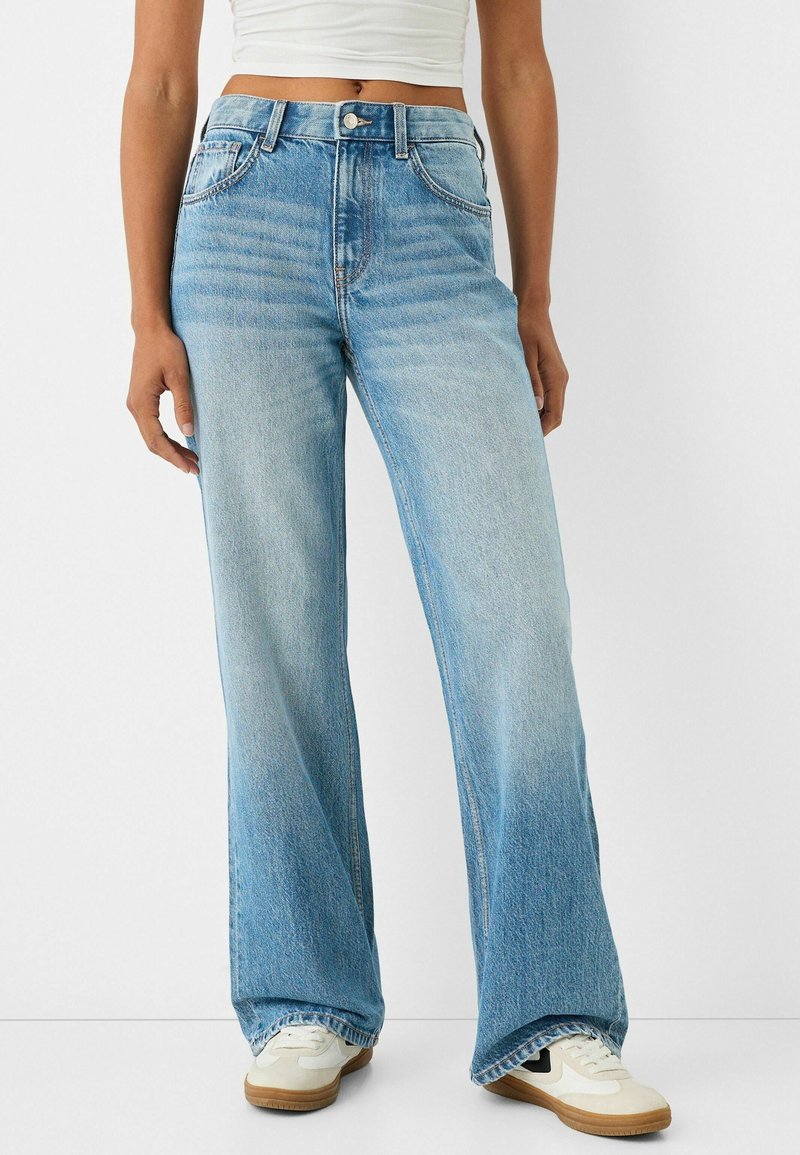 Breda jeans i ljus tvättad denim. Har hög midja, framfickor och en subtil blekning. Matchas med vita sneakers.