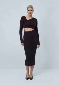 Robe ajustée à manches longues en violet foncé avec un détail découpé à la taille. Fabriquée dans un tissu lisse, longueur genou, avec une silhouette élégante.