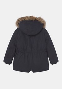 Černá zimní bunda s kapucí podšitou kožešinou, elastickým pasem, dlouhými rukávy a rozparkem vzadu na lemu, zobrazena zezadu.