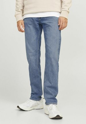 Lichtblauwe denim jeans met een rechte pijp. Draagt met een beige sweatshirt en witte sneakers. Glad textuur, geen zichtbare patronen.