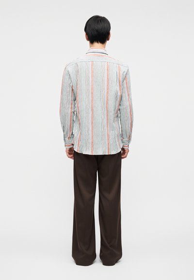 Πουκάμισο με μακριά μανίκια σε ανοιχτό μπλε χρώμα με κάθετε ς ρίγες σε πορτοκαλί και άσπρο. Διαθέτει κλασικό γιακά και ίσια ραφή στο τελείωμα, συνδυασμένο με καφέ παντελόνι.