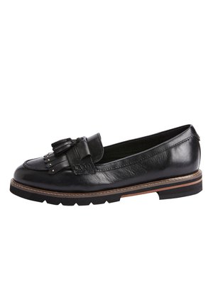 Mocassin en cuir noir à semelle plate, doté d'un pompon décoratif et d'accents métalliques. Texture lisse avec détails de coutures discrètes et bordure marron.