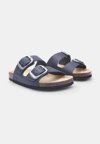 Sandali blu navy con due cinturini regolabili a fibbia, realizzati in materiale morbido su una soletta in sughero, dotati di una suola in gomma nera texture.