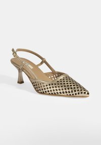 Chaussure à talon slingback en métal doré avec un bout pointu, un design en maille ouverte et un talon de 6,35 cm. Présente une sangle de cheville fine et une texture lisse.