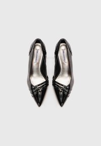Pantofi cu toc înalt, negri, cu vârf ascuțit și curele metalice cu studuri în partea din față, etichetați cu Karl Lagerfeld în interior.
