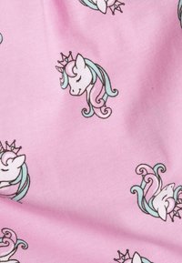 Różowy materiał z powtarzającymi się głowami jednorożców w stylu cartoon, z turkusowymi i różowymi grzywami oraz koronami. Miękka tekstura z gładkim wykończeniem.