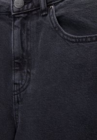 Jean en denim foncé avec une texture lisse, dotés d'une poche avant, d'une fermeture à bouton en métal et de détails de coutures contrastants.