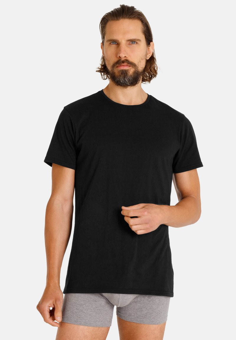 Black short-sleeve t-shirt made of cotton, featuring a round neckline. Worn with gray boxer shorts, showing a neutral background.