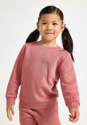 Różowy sweter z miękkiego materiału, z okrągłym dekoltem, ściągaczami na rękawach i luźnym fasonem. W komplecie z dopasowanymi spodniami.