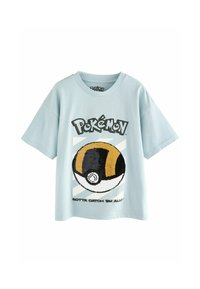 Ljusblå t-shirt med kort ärm som har en broderad svart och gul Poké Ball-grafik, med texten "Pokémon" och "Gotta Catch 'Em All!"