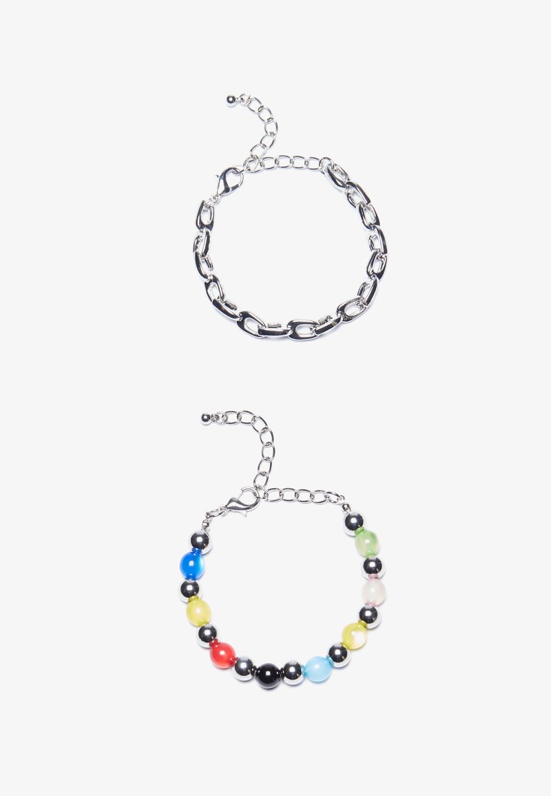 Pulseira de corrente prateada com elos alongados na parte superior. Abaixo, uma pulseira de contas coloridas com contas pretas, azuis, verdes, amarelas, vermelhas e transparentes.