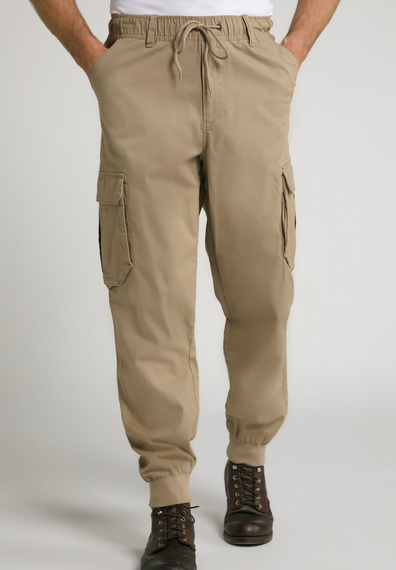 Pantaloni cargo beige con cintura elasticizzata, chiusura con cordino, tasche laterali e polsini a coste. Realizzati in tessuto leggero.