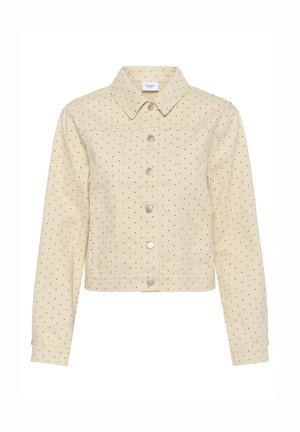 Veste courte beige à pois noirs, avec des boutons-pression argentés sur le devant, manches longues et col pointu.