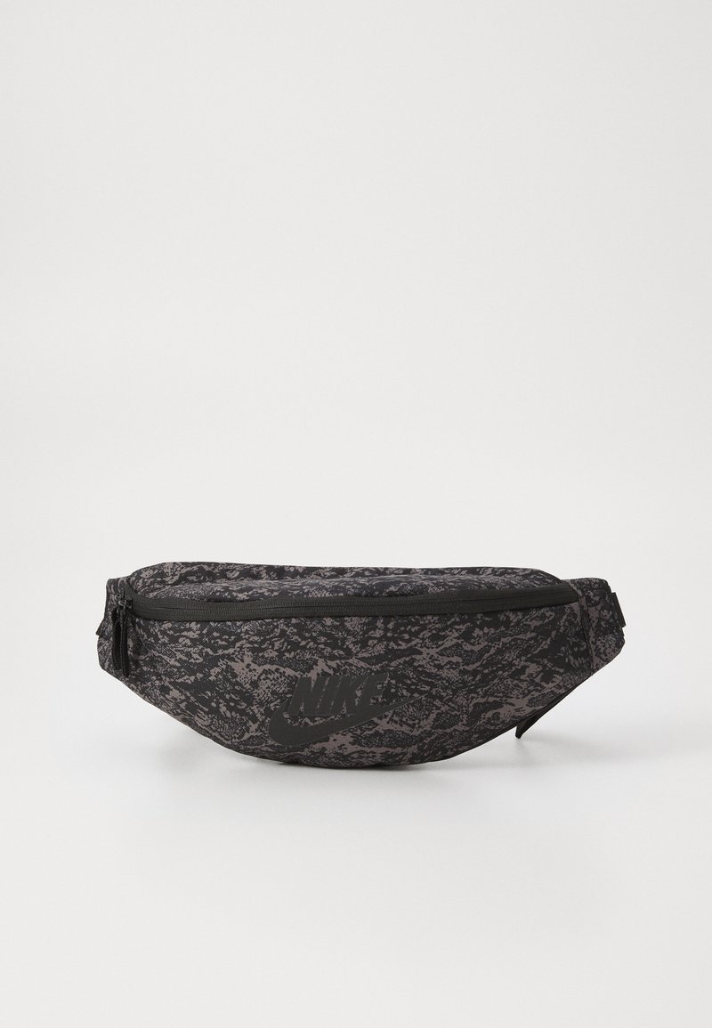 Schwarze Gürteltasche mit strukturiertem Muster, ausgestattet mit einem Reißverschluss und einem auffälligen schwarzen Nike-Logo auf der Vorderseite. Strapazierfähiges Material.