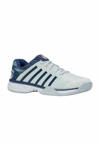 Chaussure de sport blanche et bleu marine avec tige en maille, rayures bleu marine, lacets et semelle à motifs, conçue pour le sport ou le port décontracté.