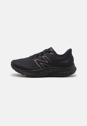 Chaussures de sport noires dotées d'une tige en mesh respirant, d'une semelle coussinée et d'accents réfléchissants, conçues pour le confort et le soutien.