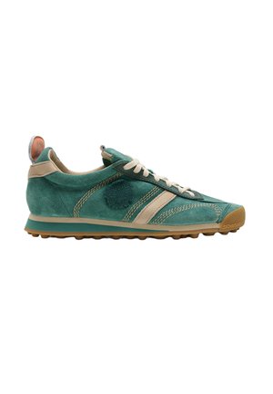 Zapatilla de ante verde con detalles beige, cordones blancos y suela marrón texturizada vista de lado sobre un fondo blanco.