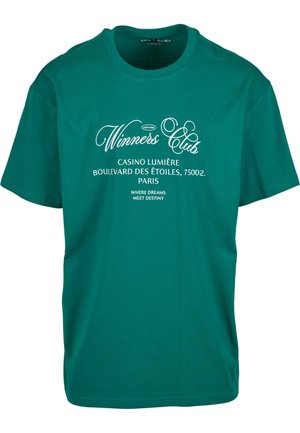 T-shirt en coton vert avec inscription blanche : "Club des Gagnants", "Casino Lumière" et "Où les Rêves Rencontrent le Destin" sur le devant. Manches courtes.