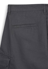 Pantalons cargo gris charbon au toucher lisse, dotés d'une poche arrière standard et de détails de couture remarquables au niveau de la taille.