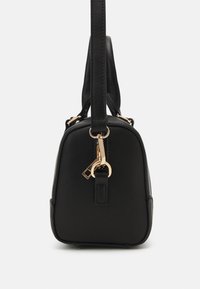 Sac à main rectangulaire noir avec fermoir doré et détail porte-clés, poignée verticale, photographié de côté sur fond blanc.