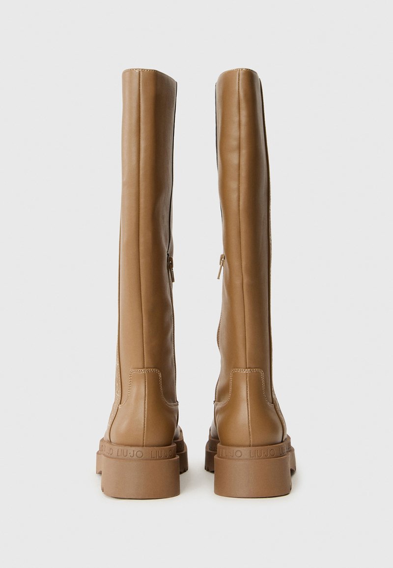 Braune Lederstiefel über das Knie mit glatter Textur, seitlichen Reißverschlüssen und einer robusten Gummisohle, geprägtem Logo entlang der Sohle.