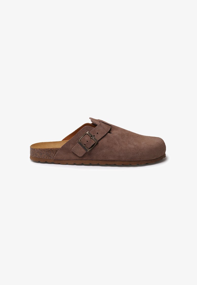 Zoccoli in suede marrone con punta arrotondata, fibbia regolabile di lato e suola in gomma testurizzata. Design semplice e minimalista.